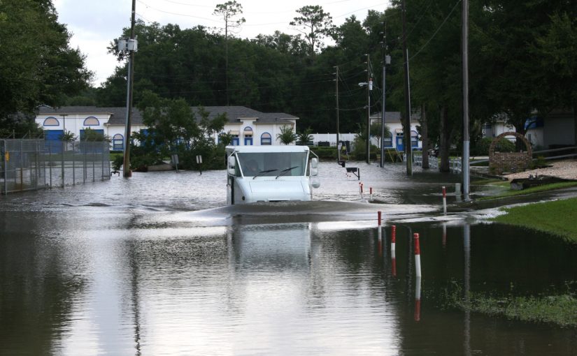 mail truck driving through flooded waters during hurricane