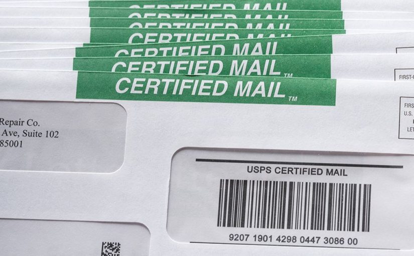 stack of certified mail with a label and certified mail tracking barcodes on envelopes