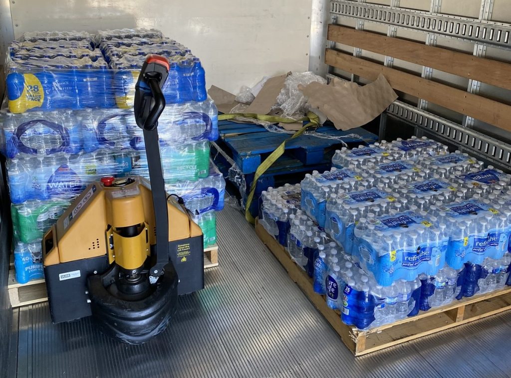 Pallets of cases of water bottles in the truck to help Phoenix Rescue Mission and Brown, an HOA management community 